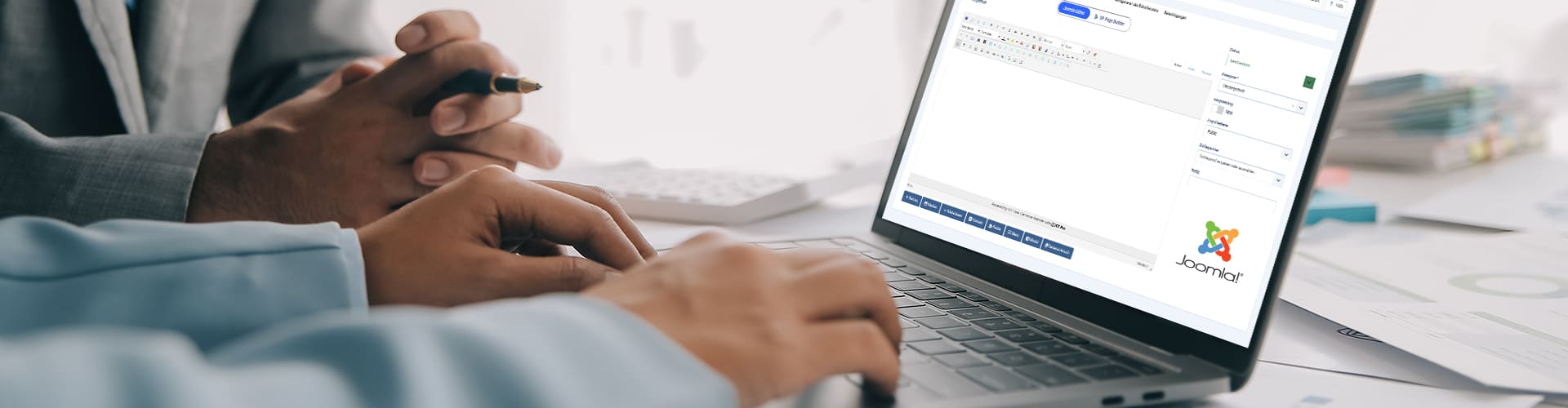 Joomla Schulung – Professionelle Schulungen für die effektive Nutzung von Jooml Zwei Personen, die an einem Laptop arbeiten, der die Joomla-Benutzeroberfläche anzeigt, während eine Person Anweisungen gibt