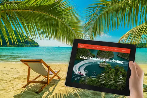 Person hält ein Tablet mit der Website von Global Communication Experts vor einem tropischen Strand