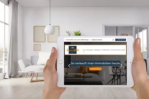 Person hält ein Tablet mit einer Immobilien-Website in einem modernen, hellen Wohnzimmer