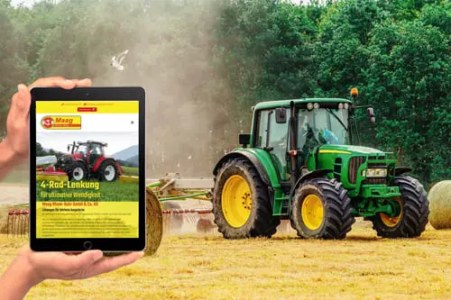 Person hält ein Tablet mit der Website von Maag Rhein-Ruhr GmbH & Co. KG, im Hintergrund ein Traktor auf einem Feld