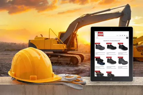 Tablet mit Work Footwear Onlineshop vor einer Baustelle mit Sicherheitshelm und Handschuhen