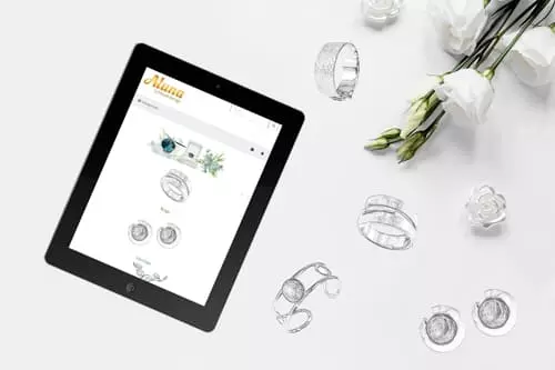 Tablet mit Aluna Schmuckdesign Onlineshop neben Schmuckstücken und Blumen