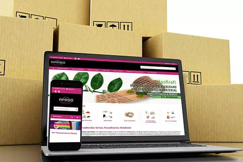 Laptop und Smartphone mit Onlineshop verpackungs-discount24 vor Kartons von von APASO Verpackungen e.K.