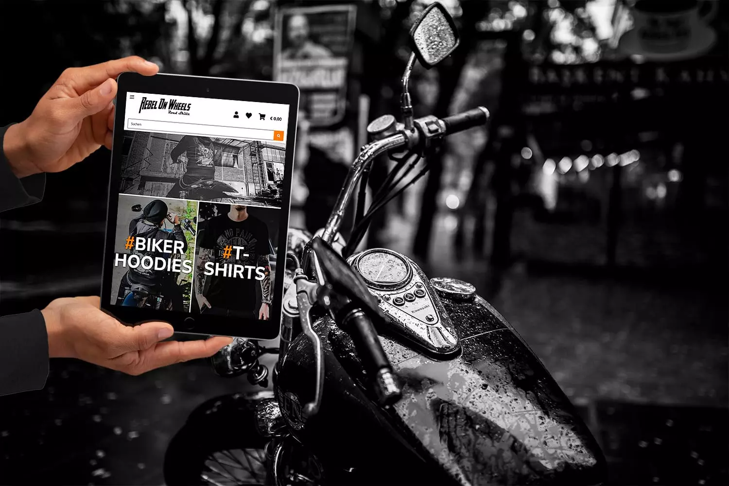 Tablet zeigt den Onlineshop von Rebel On Wheels vor einem Motorrad