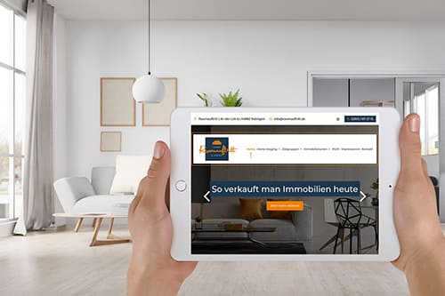 Webdesign für die Website von Raumauftritt in Ratingen Person hält ein Tablet mit einer Immobilien-Website in einem modernen, hellen Wohnzimmer