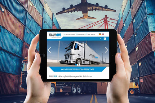 Joomla Referenz Webseite von RUNAIR GmbH - Logistik und Transport in Kelsterbach Person hält ein Tablet mit der Joomla Website von Runair GmbH, im Hintergrund ein Frachthafen mit Containern und einem Flugzeug